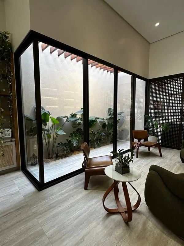 Jardim de inverno fechado com esquadrias de alumínio preto e vidro