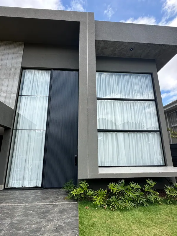 Fachada residencial moderna com esquadrias de alumínio preto e vidro
