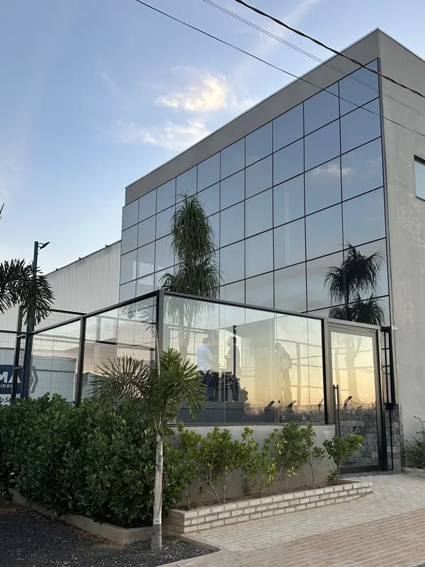 Prédio comercial com fachada em pele de vidro e guarda-corpo de vidro