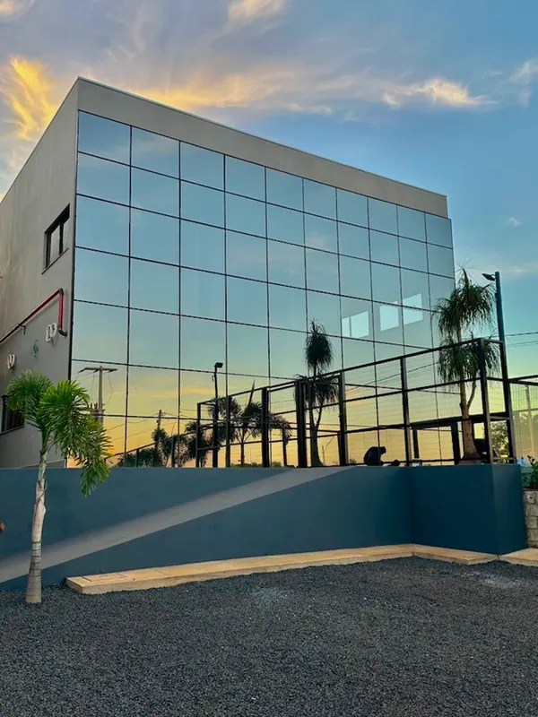 Prédio comercial com fachada em pele de vidro espelhado ao entardecer