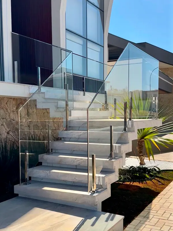 Guarda-corpo de vidro com colunas de inox em escada externa de residência