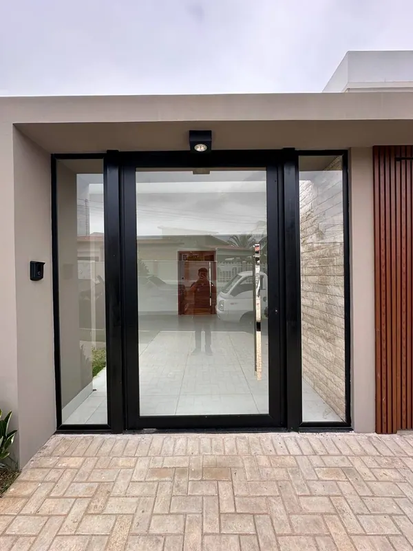 Porta de entrada de vidro com esquadria de alumínio preto